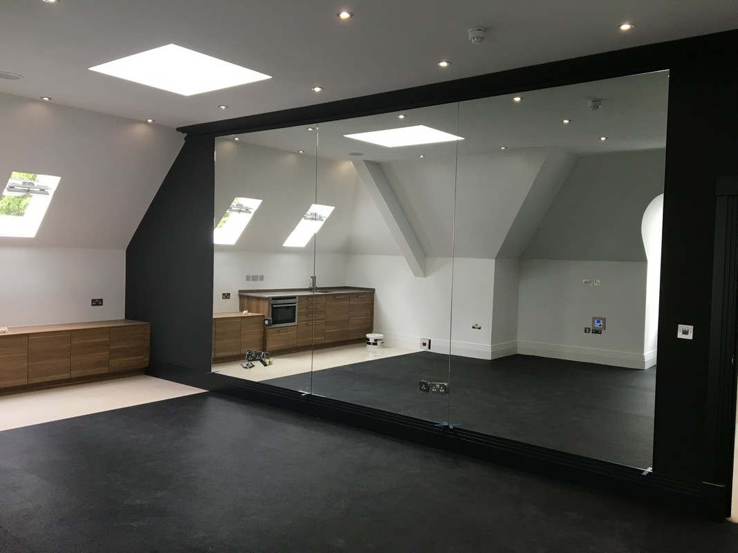 Frameless glass wall dividing loft conversion in Ealing